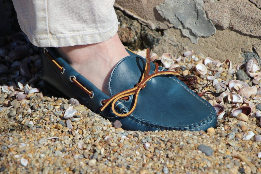 A blue and white shoes standing on a rock